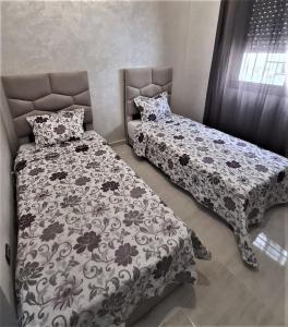 a bedroom with two beds and a headboard at Beau appartement pour votre séjour a Casablanca Bouskoura in Bouskoura