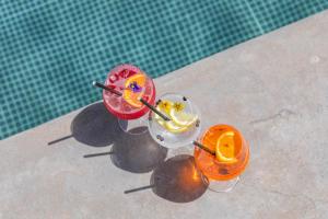 two cocktails sitting next to a swimming pool at Grand Hotel Du Golfe - Spa & Restaurant in Collioure +73 photos