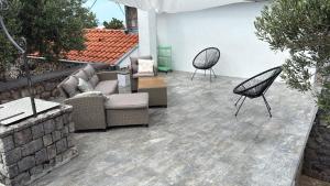 un patio con 2 sillas, un sofá y mesas en House Bralići, en Stari Grad