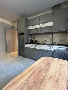 a kitchen with gray cabinets and a wooden table at Marias Apartment in Alexandroupoli