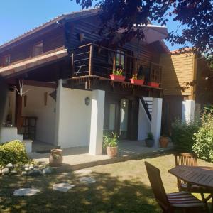 a house with a balcony and a patio at La GRANGE de MOMBEL in Losse