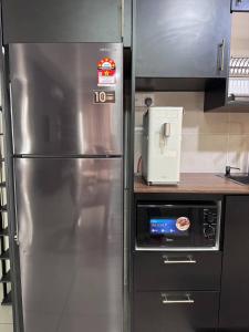 a kitchen with a stainless steel refrigerator in a kitchen at Bali Residence by D'RZ Muslim Seaview Homestay in Melaka