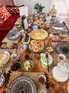 a wooden table with plates of food on it at Dar Surfana Morocco in Aourir