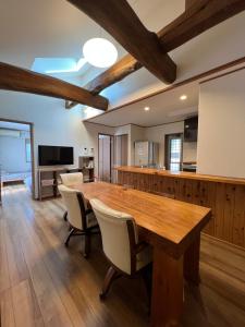 ein großes Esszimmer mit einem Holztisch und Stühlen in der Unterkunft moksa House ヒリゾ浜まで車で10分 in Kanō