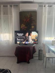 a living room with a table and a tv at Casa al-andalus in Granada +29 photos