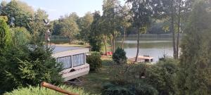 a caravan parked on the side of a lake at U Madzi i Arka in Gawliki Wielkie
