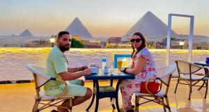 开罗mystery Of pyramids view的坐在金字塔前桌边的男女