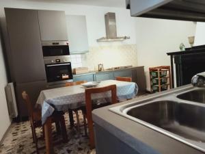 a kitchen with a sink and a table with chairs at Delizioso appartamento al centro di Bosco in San Giovanni a Piro +18 photos