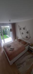 a bedroom with a large bed with a large window at Apartament Whiteblue Dream 2 Kołobrzeg z ogródkiem & sauna & fitness & bawialnia dla dzieci in Kołobrzeg
