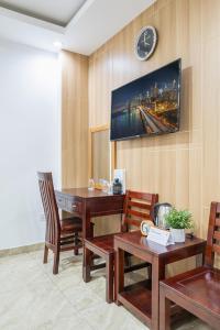 a room with a desk and a clock on the wall at Cozrum - New Sun Hotel in Ho Chi Minh City