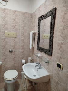 a bathroom with a sink and a toilet and a mirror at Hotel La Selce in Monselice