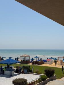 a view of a beach with umbrellas and the ocean at Elite residence ain elsokna in Ain Sokhna