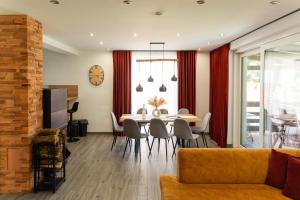 a dining room and living room with a table and chairs at Chaty ForRest in Stará Turá