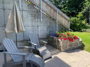 two chairs and an umbrella next to a planter with flowers at Ferienwohnung am Storchennest in Ichenhausen