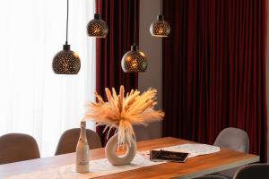 a dining room table with pendant lights and a vase at Chaty ForRest in Stará Turá