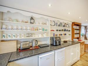 una cucina con ripiani bianchi e piano di lavoro di Garden Cottage a Tetford Altre 21 foto