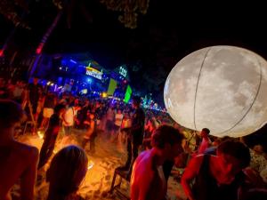 a crowd of people on the beach at night at Sleepymoon Hostel in Thongsala