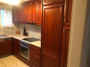 a kitchen with wooden cabinets and a stove top oven at Villa Zante Estrella in Kalamaki +18 photos