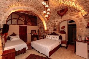 Un dormitorio con dos camas y una pared de piedra. en Ali paşa konağı mardin, en Mardin