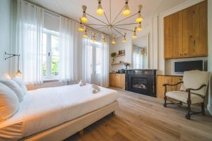 a bedroom with a bed and a chair and a fireplace at B&B Barabas in Bruges