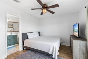 Un dormitorio con una cama y un ventilador de techo. en Perdido Beach Bungalow, en Pensacola