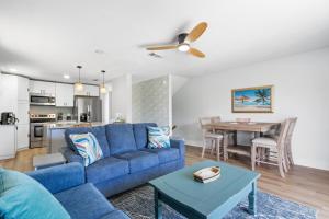 Una sala de estar con un sofá azul y una mesa. en Perdido Beach Bungalow, en Pensacola 35 fotos más