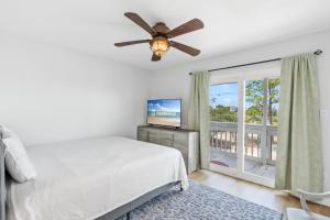 Un dormitorio con una cama y un ventilador de techo. en Perdido Beach Bungalow, en Pensacola