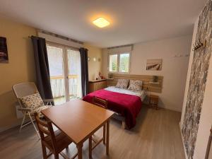 une chambre avec un lit et une table et une salle à manger dans l'établissement Alisiers 18, à Eugénie-les-Bains