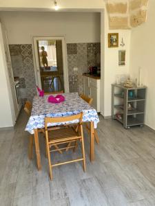 a kitchen with a table with chairs and a table and a counter at Il Fenicottero in San Pietro in Bevagna +24 photos