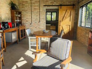 a dining room with a table and a chair at Apple Cottage in Grabouw +41 photos