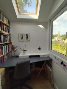 a desk in a room with a window and a book shelf at Hilltop view - 2 bedroom house with garden bbq - private parking - 12min to Uzupis anytime in Vilnius