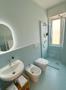 een badkamer met een wastafel, een toilet en een spiegel bij Ponente Blue Appartamenti, 7 in Arma di Taggia