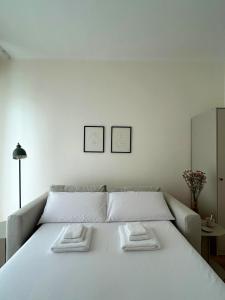 een wit bed met 2 kussens erop bij Ponente Blue Appartamenti, 7 in Arma di Taggia