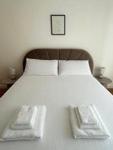 een wit bed met twee witte handdoeken erop bij Ponente Blue Appartamenti, 7 in Arma di Taggia