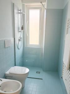 een badkamer met toilet, wastafel en raam bij Ponente Blue Appartamenti, 7 in Arma di Taggia +14 foto's