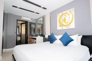 a bedroom with a large white bed with blue pillows at Beachfront Family Pool 2 Bed Room Patong Phuket in Patong Beach