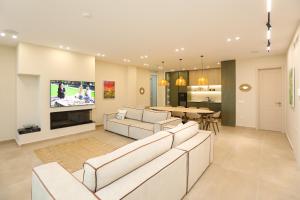 a living room with two couches and a tv at Villa Palasea in Vlorë