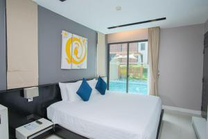 a bedroom with a large white bed with blue pillows at Beachfront Family Pool 2 Bed Room Patong Phuket in Patong Beach