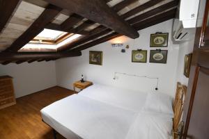 a bedroom with a white bed and a skylight at Appartamento VIAROMA58 - Vicinissimo al mare con clima e posto auto in Marina di Campo