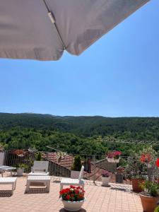 アッセルジにあるPIAZZETTA DEL FORNO GRAZIOSO BILOCALE ad ASSERGIの椅子と花のあるパティオの景色を望めます。