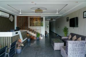 a living room with couches and a tv on a wall at Hotel Score The Heaven in Zirakpur