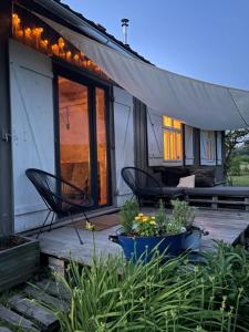 a house with two chairs and a porch with plants at Siedlisko pod Lipami in Lipniki +15 photos