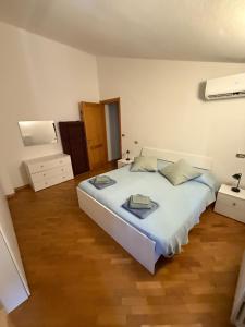 a bedroom with a large white bed and a wooden floor at B&B Emilia 330 Imola Centro Apartment in Imola
