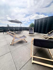 a patio with chairs and an umbrella on a roof at Chalet Schneeglück Winterberg mit Sauna Terrasse Grill 11 Gäste in Winterberg