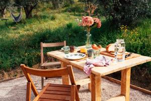 a wooden table with a vase of flowers on it at Stargazer - Glamping Maremma, Toscana in Roccastrada +18 photos