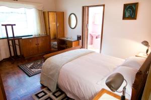 1 dormitorio con 1 cama y baño con ventana en Luisa's Place, en Pretoria