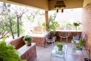 Un patio al aire libre con sillas y plantas. en Luisa's Place, en Pretoria