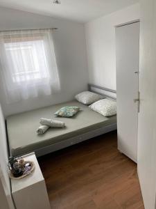 un letto in una camera con due cuscini e una finestra di Apartment Mona Vir a Vir (Puntadura)