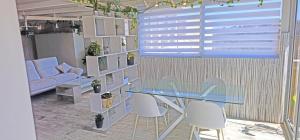a dining room with a glass table and white chairs at Satori Studio - open plan seaviews private terrace & shared pool in Il-Pergla