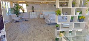 a large room with couches and plants on shelves at Satori Studio - open plan seaviews private terrace & shared pool in Il-Pergla